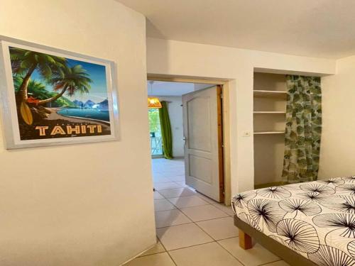 ein Wohnzimmer mit einer Couch und einem Bild an der Wand in der Unterkunft Vos vacances à 800m de la plage de l anse figuier in Rivière-Pilote