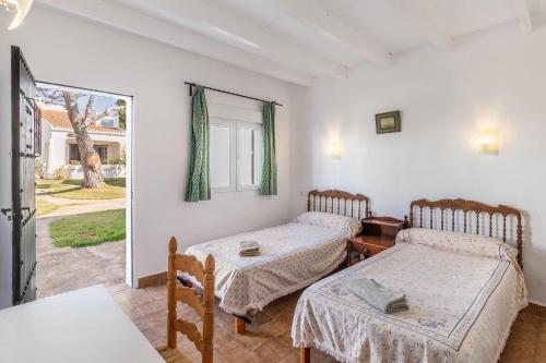 カラ・セレナにあるCala Serena Beach 2のベッド2台とテーブルのある部屋