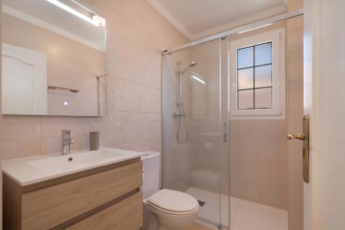 a bathroom with a shower and a toilet and a sink at Luxury villa in Islantilla