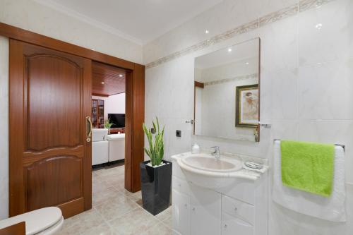 une salle de bain avec un lavabo, des toilettes et un miroir dans l'établissement Casa Los Llanos Teseguite Lanzarote, à Teguise