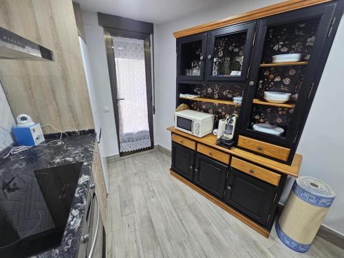 a living room with a cabinet filled with dishes at El Cierzo de Sediles in Sediles