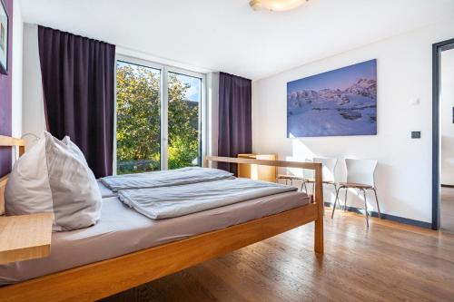 a bedroom with a bed and a desk and windows at Haus Börnsteen in Zingst