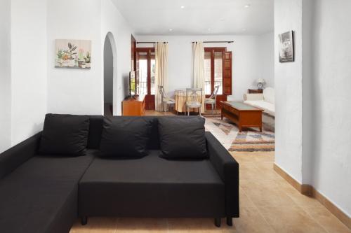 a living room with a black couch in a room at Plaza Iglesia in Frigiliana