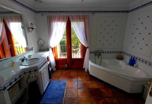 a bathroom with a tub and a sink and a bath tub at Robis Moraira in Benissa