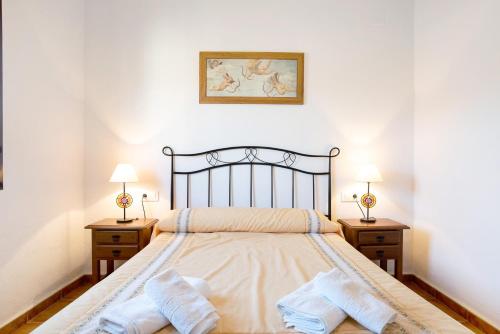 een slaapkamer met een groot bed met twee nachtkastjes bij Casa Juan Solo Familias in Cádiz