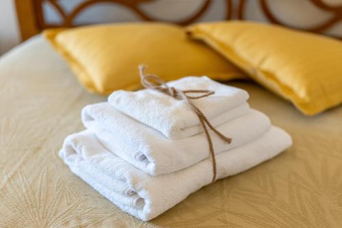 una pila di asciugamani appoggiata sopra un letto di Gma Home Primo Piano a Pulsano