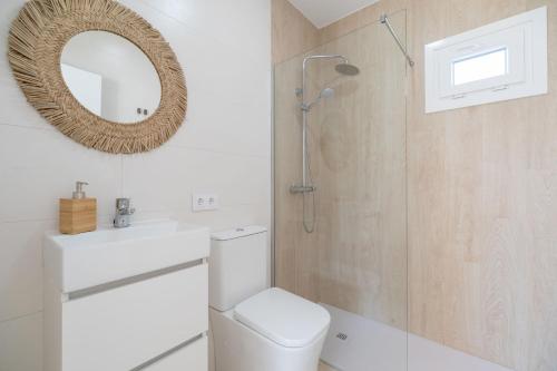 ein Bad mit einer Dusche, einem WC und einem Spiegel in der Unterkunft Villa Morales in Chiclana de la Frontera