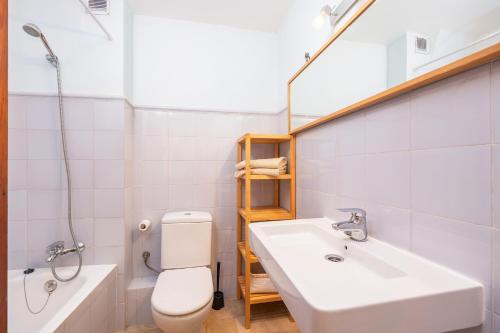 Un baño con lavabo, inodoro y espejo. en Cas Sitger, en Felanitx