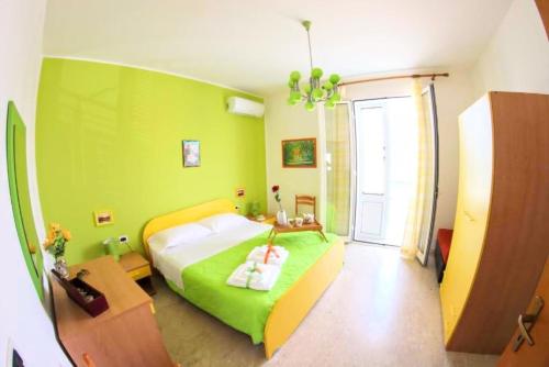 um quarto verde com uma cama e uma janela em Appartamento Il Gabbiano Balestrate em Balestrate