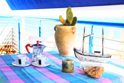 uma mesa com uma toalha de mesa e um barco de brinquedo em cima em Appartamento Il Gabbiano Balestrate em Balestrate