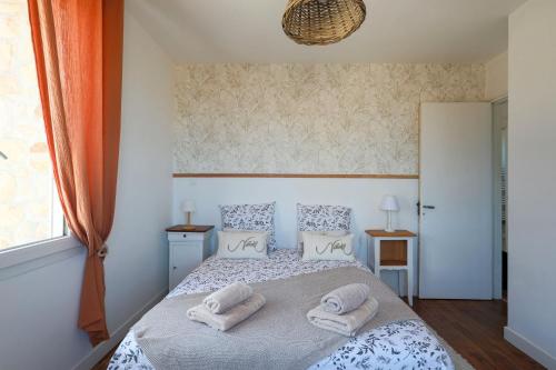 a bedroom with a bed with towels on it at Villa Les Agapanthes in Paimpol
