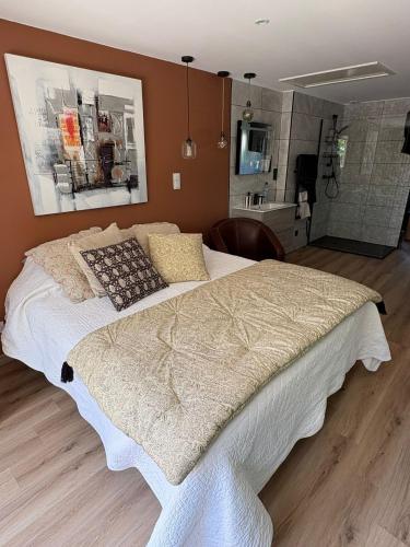 a bedroom with a large bed and a bathroom at Aux Amelierets in Saint-Just