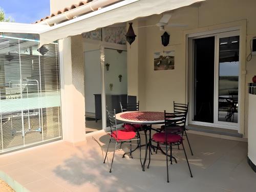 Un patio con una mesa y sillas en un balcón. en Gîte Du Midi - La Noria, en Cazouls-lès-Béziers