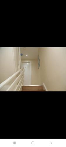 a white room with a wooden floor and a door at BUDGET Twin Double Rooms in Thamesmead