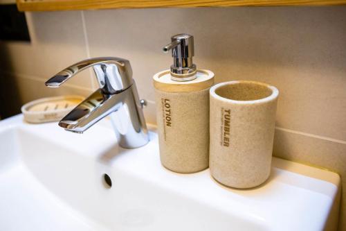 a bathroom sink with two cups sitting on it at Appartamento Via Livigno in Isolaccia