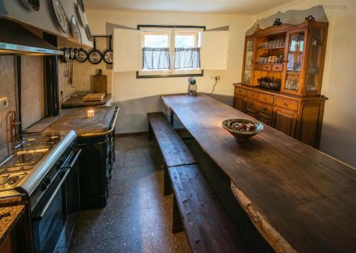 a kitchen with a large wooden table and benches at Masia Can Felix Santa Fe in Barcelona