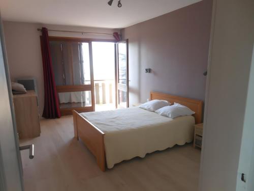a bedroom with a bed and a large window at Appartement T3 in Embrun