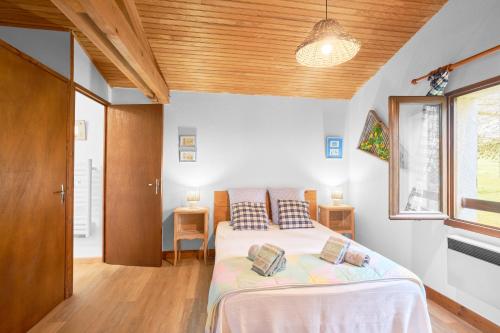 a bedroom with a bed and a wooden ceiling at Maison La Plaine, En Périgord in Saint-Laurent-la-Vallée