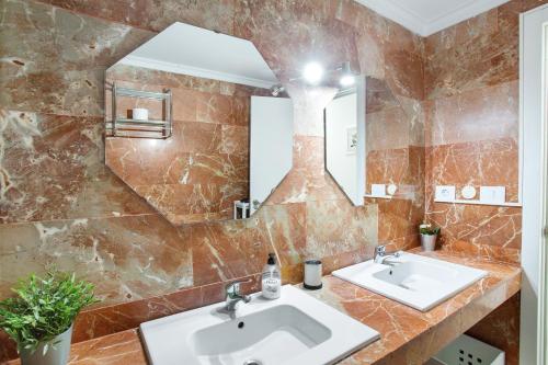 Un baño con dos lavabos y un espejo. en Beautiful Apartment 1115 Central, en San Bartolomé