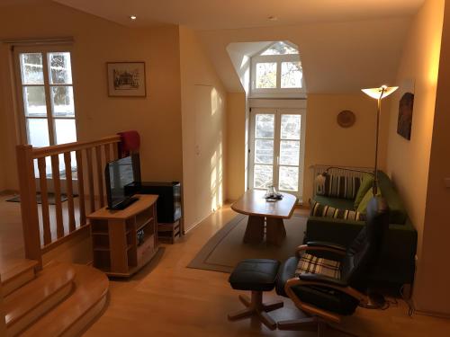 a living room with a couch and a tv at Weingut Ilmbacher Hof in Iphofen