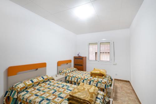 zwei Betten in einem Zimmer mit weißen Wänden in der Unterkunft Casa Menvil in Sant Jordi de Cercs
