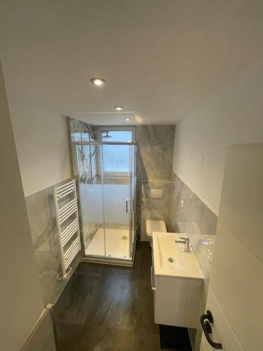 a small bathroom with a sink and a shower at Schöne Ferienwohnung in Schwerte Central in Schwerte