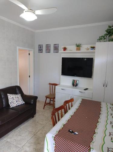 ein Wohnzimmer mit Couch und Flachbildfernseher in der Unterkunft Refúgio a beira-mar in Tramandaí