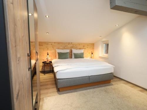 une chambre avec un grand lit blanc dans une pièce dans l'établissement Tirola Platzl, à Hopfgarten im Brixental