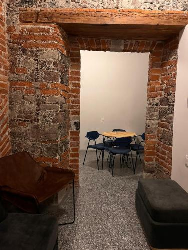 a room with a table and chairs and a brick wall at Chilango BnB in Mexico City