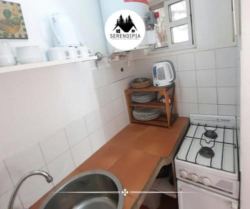 eine kleine Küche mit Spüle und Herd in der Unterkunft Serendipia Chalet 2 Naturaleza y Pileta in La Cumbre