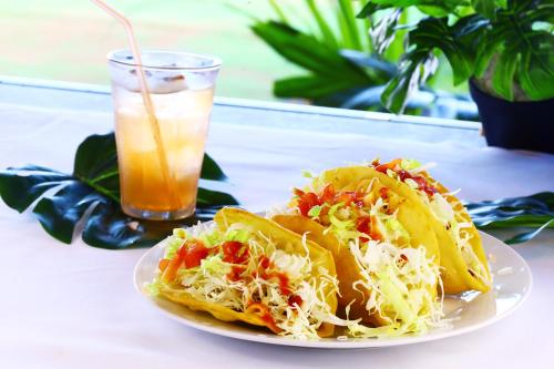 a plate of food with a taco and a drink at DUOマーメイドステイ in Nakagusuku