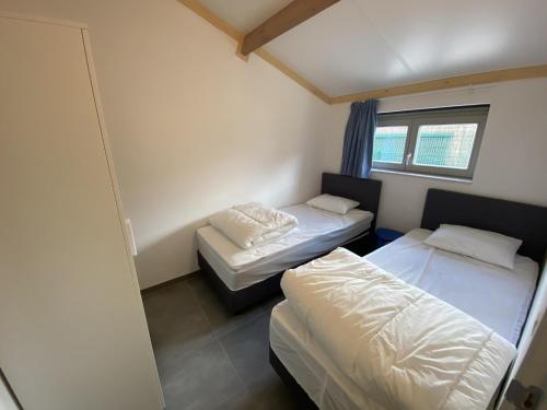 Un dormitorio con dos camas y una ventana. en Westhinder II H52, en Koksijde