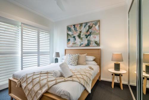 een slaapkamer met een bed en een schilderij aan de muur bij Luxury Pool Home Near Noosa & Coolum Sleeps 8 in Peregian Springs