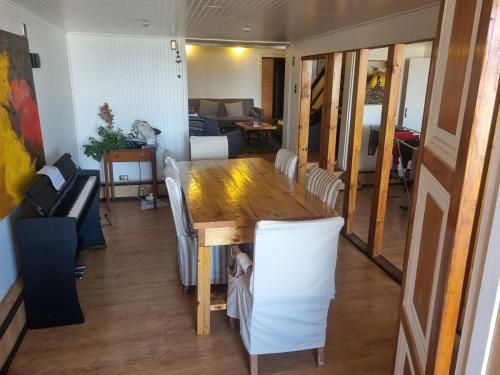 a living room with a wooden table and white chairs at Comfortable and family house in Cerro Alegre in Valparaíso