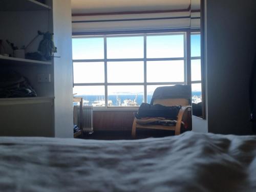 a bedroom with a bed and a large window at Comfortable and family house in Cerro Alegre in Valparaíso