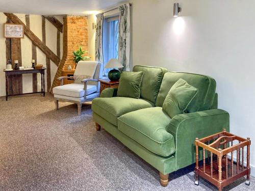 カンタベリーにあるThe Friars Apartment, Eastbridge Hospitalの緑のソファと椅子のあるリビングルーム