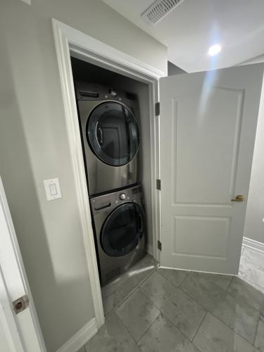 Basement في برامبتون: غرفة غسيل فيها غسالة ومجفف