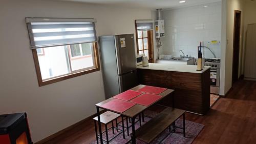 a kitchen with a table and a refrigerator at Kabañas Bosque De Alamos in Puerto Aisén