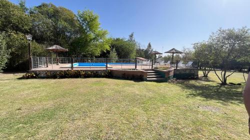 a large yard with a swimming pool with a deck at Cabañas Aldea Blanca in Merlo