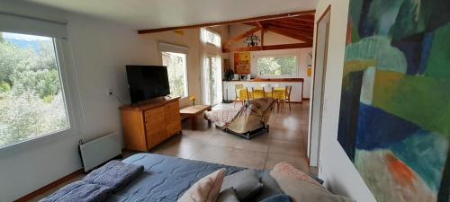 une chambre avec un lit et un salon dans l'établissement La Casa de los Cuadros, à Lago Puelo