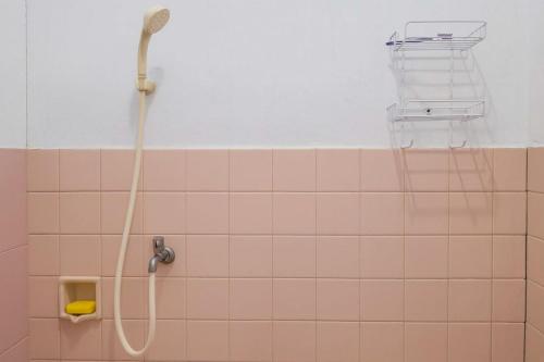 a shower in a bathroom with pink tiles at RedDoorz at Hotel Galuh Putra Pangandaran in Pangandaran