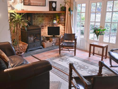 a living room with a fireplace and a television at Gareside Lodge in Rhu
