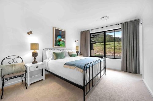 une chambre avec un lit et une grande fenêtre dans l'établissement Burrugin Lodge, à Beaumont