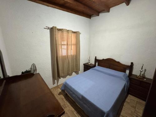 ein Schlafzimmer mit einem Bett und einem Tisch und einem Fenster in der Unterkunft Las chochitas 6p in Punta Del Diablo