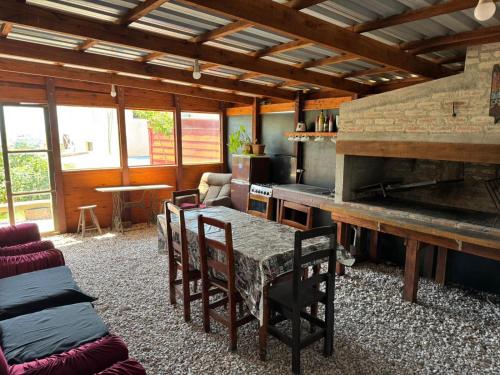 ein Wohnzimmer mit Tisch und Stühlen und eine Küche in der Unterkunft Las chochitas 6p in Punta Del Diablo