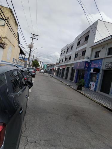 a street with cars parked on the side of the road at Pousada Duda Lins in São Vicente