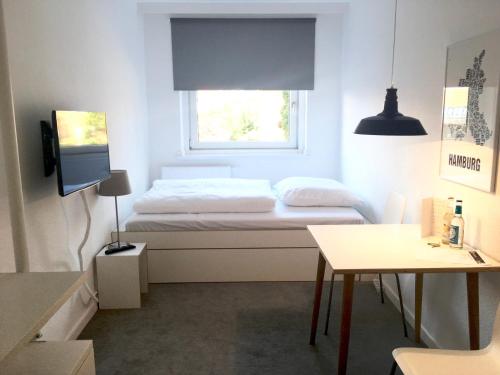 a small white room with a bed and a window at Boardinghouse St.Pauli in Hamburg