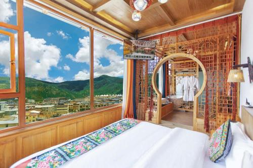 a bedroom with a bed and a large window at The Peak Living in Shangri-La