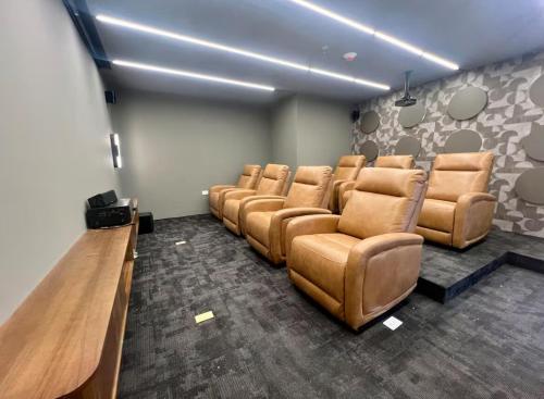 a waiting room with brown leather chairs and a table at Cozy & Modern Apartment in Lirios de Miraflores in Tegucigalpa