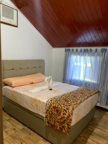 a bedroom with a bed with a cheetah blanket at Chácara Recanto dos Fortes in Casimiro de Abreu